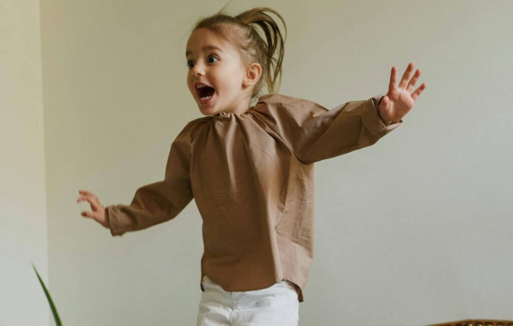 #38 FamilyShift Beitragsbild: kleines Mädchen hüpft auf einer Couch