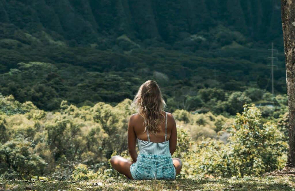 #43 FamilyShift Beitragsbild: Eine Frau sitzt im Schneidersitz in der Natur