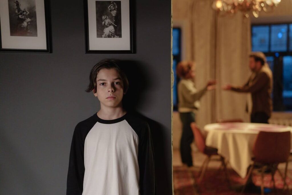 #62 ziemlichglücklich Beitragsbild: Junge steht an einer Wand.