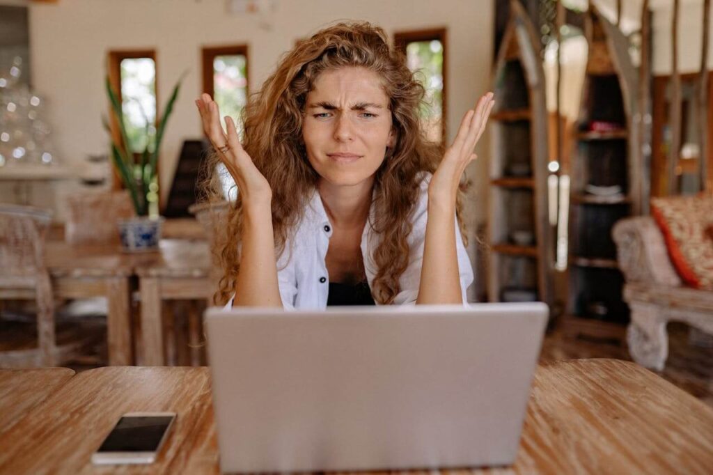 #94 ziemlichglücklich Beitragsbild: Eine Frau sitzt ärgerlich vor ihrem Laptop